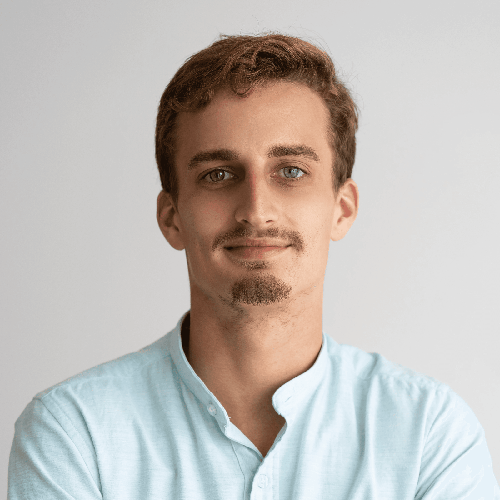 Professional portrait of a young man with a moustache and beard.